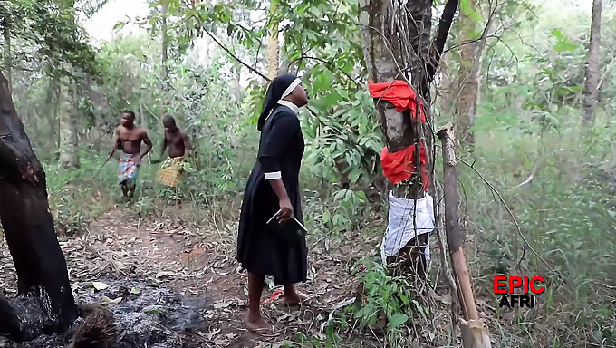 Faphousen Uusimmassa Videossa On Kolmikko Afrikkalaisten Soturien Ja Ulkomaisten Lähetyssaarnaajien Kanssa Ulkoilmaympäristössä.